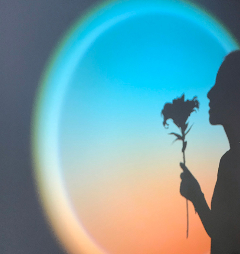 Person enjoying the warm glow of the Sunset Lamp